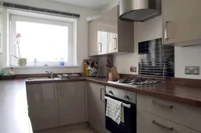 a kitchen with a sink and a stove top oven at Edinburgh Family-Friendly Flat Walkable from Princess street in Edinburgh