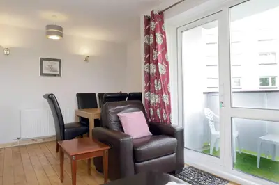 a living room with a leather chair and a table at Edinburgh Family-Friendly Flat Walkable from Princess street in Edinburgh
