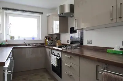 a kitchen with a sink and a stove top oven at Edinburgh Family-Friendly Flat Walkable from Princess street in Edinburgh