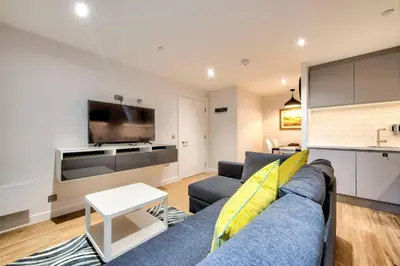 a living room with a blue couch and a tv at Lovely 1-Bedroom Unit Near Edinburgh Castle in Edinburgh
