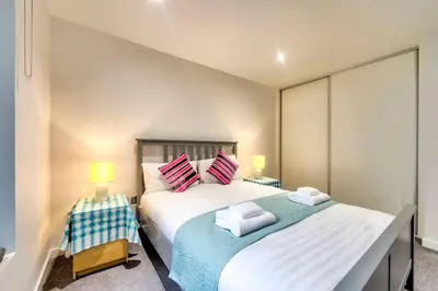 a bedroom with a large bed and two lamps at Lovely 1-Bedroom Unit Near Edinburgh Castle in Edinburgh