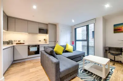 a living room with a couch and a kitchen at Lovely 1-Bedroom Unit Near Edinburgh Castle in Edinburgh
