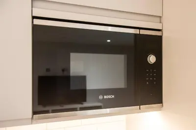 a microwave oven is attached to a wall at Lovely 1-Bedroom Unit Near Edinburgh Castle in Edinburgh