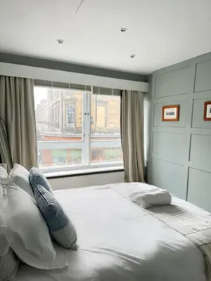 a bedroom with a large bed with a window at Duplex - City Centre 4-Bed Retreat in Edinburgh