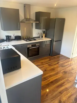 a kitchen with stainless steel appliances and wooden floors at NEW - 3 Bedroom House in East Kilbride in East Kilbride