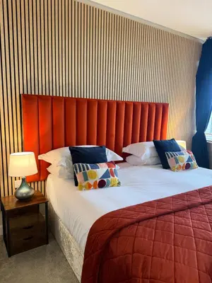a bedroom with a large bed with a red headboard at The courtyard bar, kitchen, rooms in Falkirk