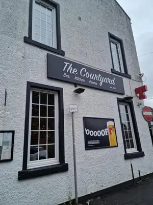 a sign on the side of a building at The courtyard bar, kitchen, rooms in Falkirk