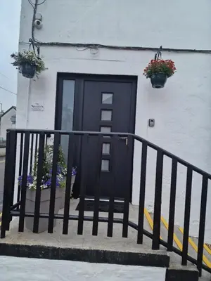 a black door on a white building with flowers at The courtyard bar, kitchen, rooms in Falkirk