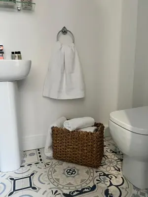 a bathroom with a toilet and a basket of towels at The courtyard bar, kitchen, rooms in Falkirk