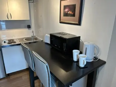 a kitchen with a table with a microwave and chairs at Castle Walk Apartment in Stirling