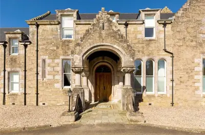 an old stone building with a wooden door at Stunning Flat in Loch Lomond in Luss