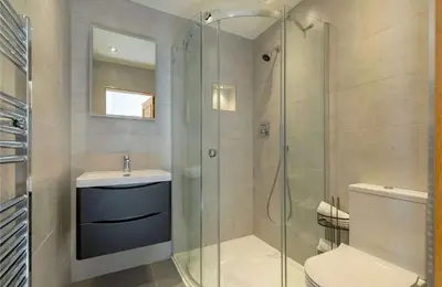 a bathroom with a shower and a toilet and a sink at Stunning Flat in Loch Lomond in Luss