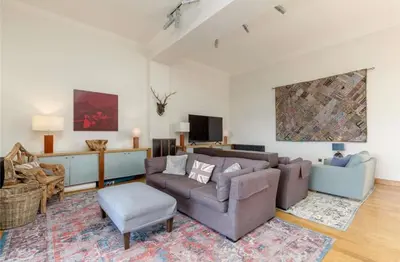a living room with a couch and a chair at Stunning Flat in Loch Lomond in Luss