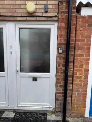 a white door with a large window on a brick building at One bedroom studio in Moffat