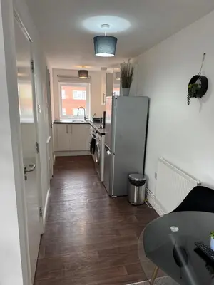 a small kitchen with a refrigerator and a table at One bedroom studio in Moffat