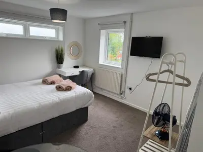 a bedroom with a bed and a desk and a television at One bedroom studio in Moffat