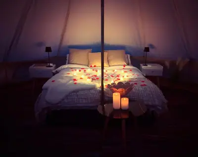 a bedroom with a bed with candles on it at Infinite Sky camping in Moffat