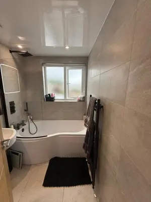 a bathroom with a tub and a sink and a window at Best stay in the bay in Saint Davids