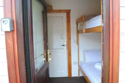 a door leading into a room with a bunk bed at Rowardennan Rooms in the lodge Lodge no 2 in Rowardennan
