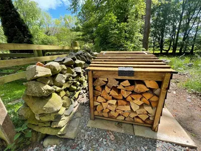 a pile of fire wood in a wooden box at Wood Cottage in Peebles