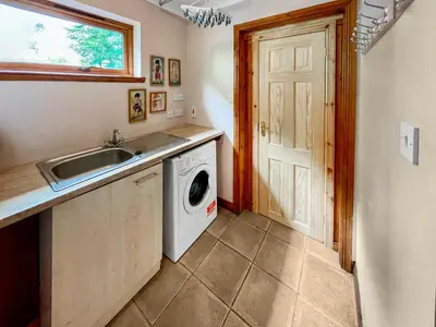 a kitchen with a sink and a washing machine at Foxglove Cottage 2 - Uk50020 in Drymen