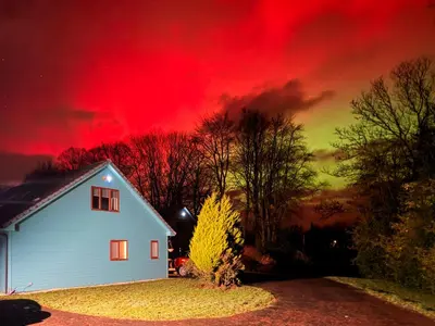 a white house with a red sky in the background at Foxglove Cottage 2 - Uk50020 in Drymen