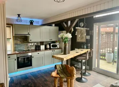 a kitchen with white cabinets and a wooden table at Breacan Lodge in Hunters Quay