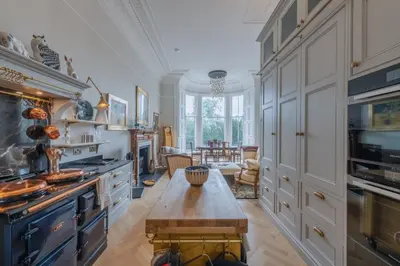 a large kitchen with a table in the middle at Luxury West End flat with stunning bay window views in Edinburgh
