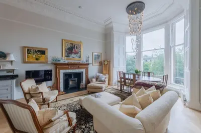 a living room with a couch and chairs and a fireplace at Luxury West End flat with stunning bay window views in Edinburgh