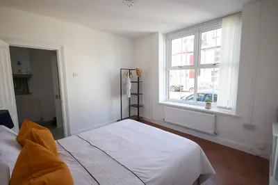 a white bedroom with a bed and a window at Modern 2Bed Garden Apartment in Heart of Penarth in Moffat