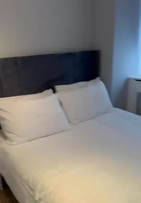 a bed with white sheets and pillows in a room at 2Bedrooms flat in knightstbridge in Moffat
