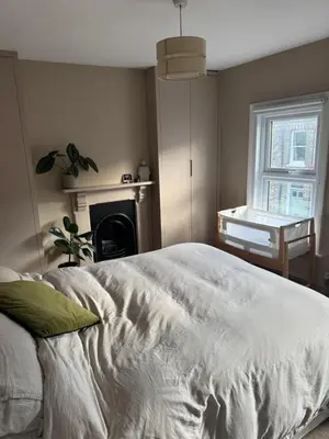 a bedroom with a white bed and a fireplace at Station House in Moffat