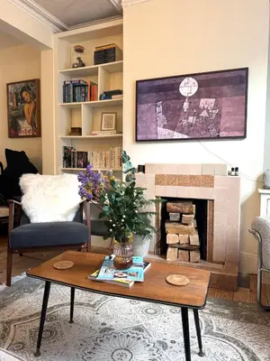 a living room with a table and a fireplace at Station House in Moffat