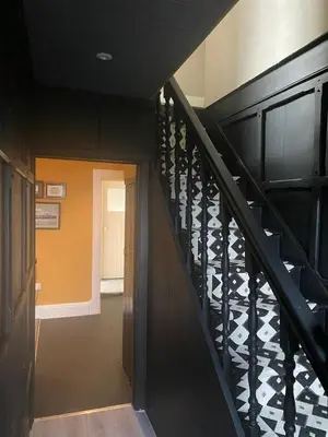 a stairway with a black railing and a hallway at Fernbank Cottage - Bruichladdich, Isle of Islay in Bruichladdich