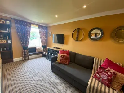 a living room with a couch and a window at Fernbank Cottage - Bruichladdich, Isle of Islay in Bruichladdich