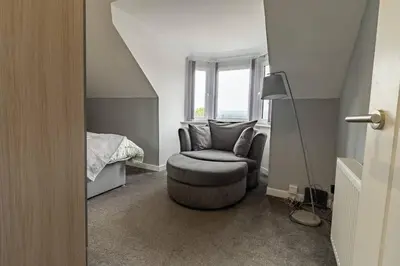 a living room with a chair and a bed at The Loft - 3 bedroom in Crieff in Crieff