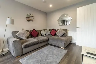 a living room with a couch and a mirror at The Loft - 3 bedroom in Crieff in Crieff