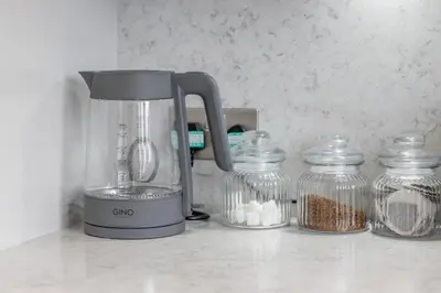 a blender on a counter next to jars of food at The Well - 3 bedroom apartment in Motherwell