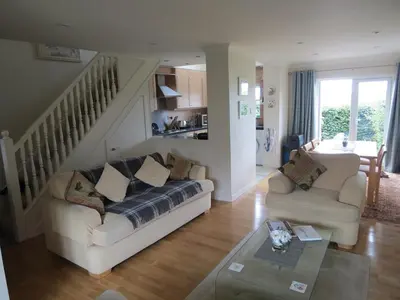 a living room with a couch and a staircase at Morvern Cottage in Craobh Haven
