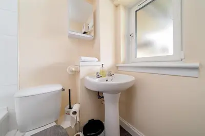 a bathroom with a sink and a toilet and a mirror at Glasgow Apartment near Hydro & SECC, Finnieston in Glasgow