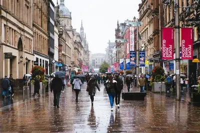 a group of people walking down a street with umbrellas at Glasgow Apartment near Hydro & SECC, Finnieston in Glasgow