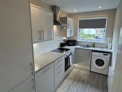 a kitchen with white cabinets and a sink and a dishwasher at Newly Renovated Flat Edinburgh - 2 x Double Beds in Edinburgh