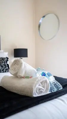 a bed with a pile of towels on it at Curtis Apartment in Glasgow