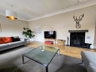 a living room with a couch and a fireplace at Balmory Stables North, luxury stable conversion in Ascog