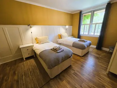 a hotel room with two beds and a window at Balmory Stables South - luxury stable conversion in Ascog