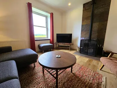 a living room with a couch and a table at Balmory Stables South - luxury stable conversion in Ascog