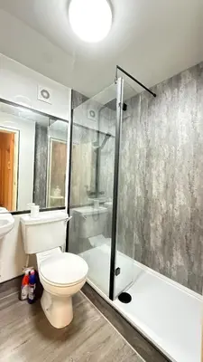 a bathroom with a toilet and a glass shower at Glasgow One Bedroom Flat close to city centre and all amenities in Glasgow