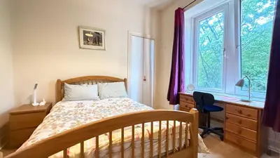 a bedroom with a bed and a desk and a window at Glasgow One Bedroom Flat close to city centre and all amenities in Glasgow