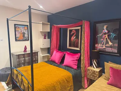 a bedroom with a canopy bed with pink pillows at Jett Joy in Moffat