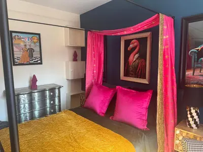 a bedroom with a canopy bed with pink pillows at Jett Joy in Moffat